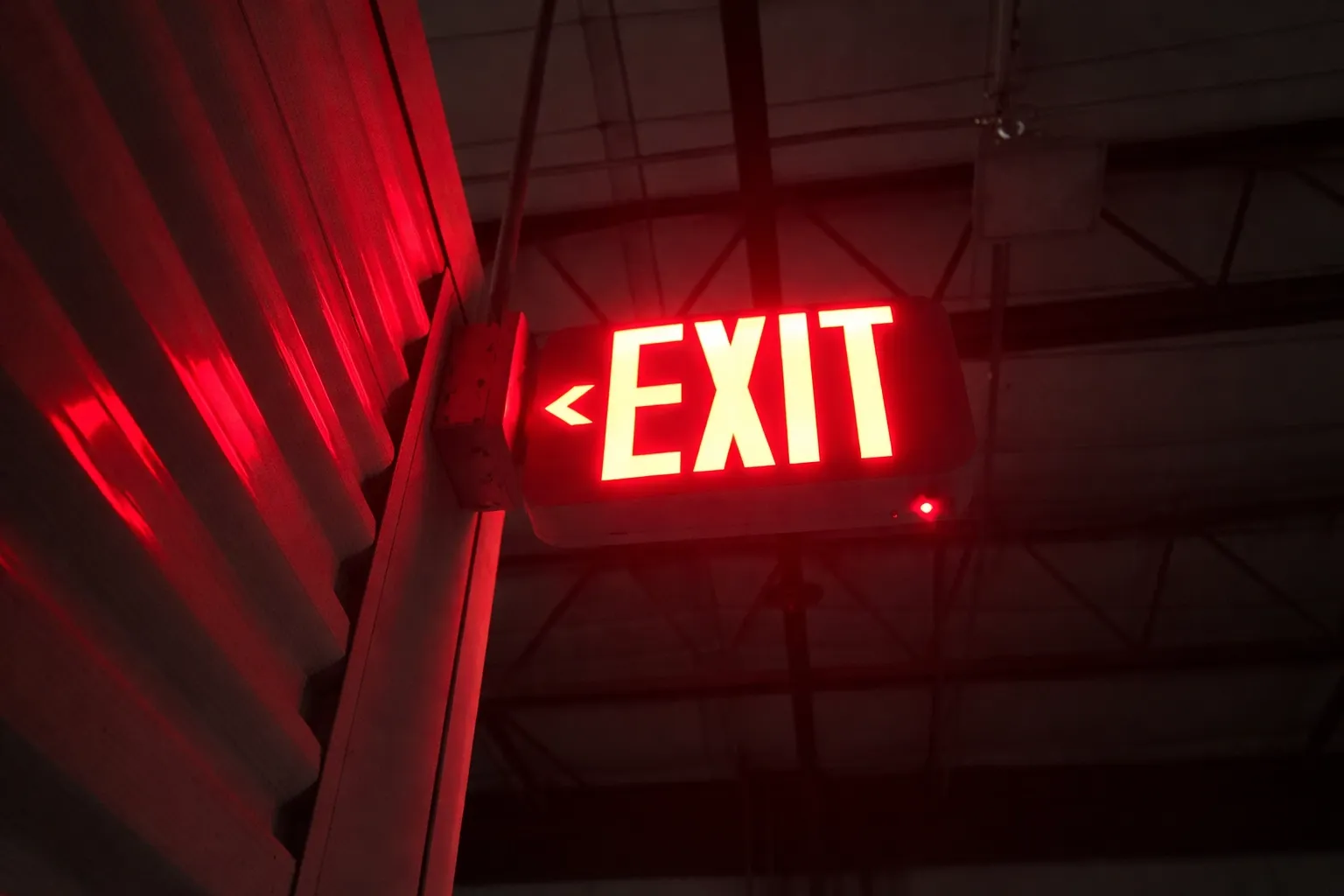 Illuminated exit sign re-energized and repositioned through coordinated electrical correction work.